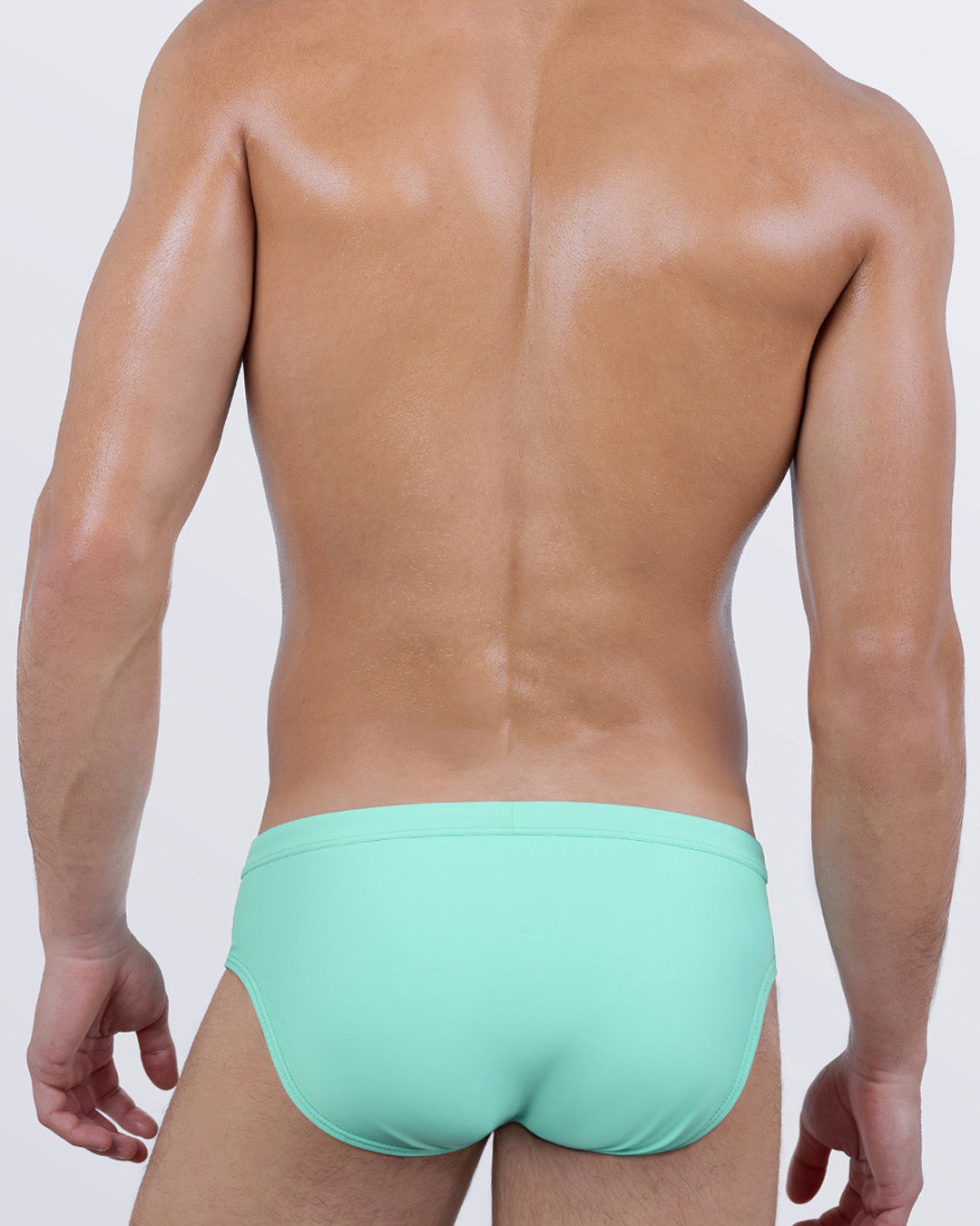 Back view of AQUA LITE men’s swim briefs, showing off a clean, minimal design in a minty pastel hue. Features a low-rise seat and snug fit that contours the body for a confident, no-fuss poolside look.