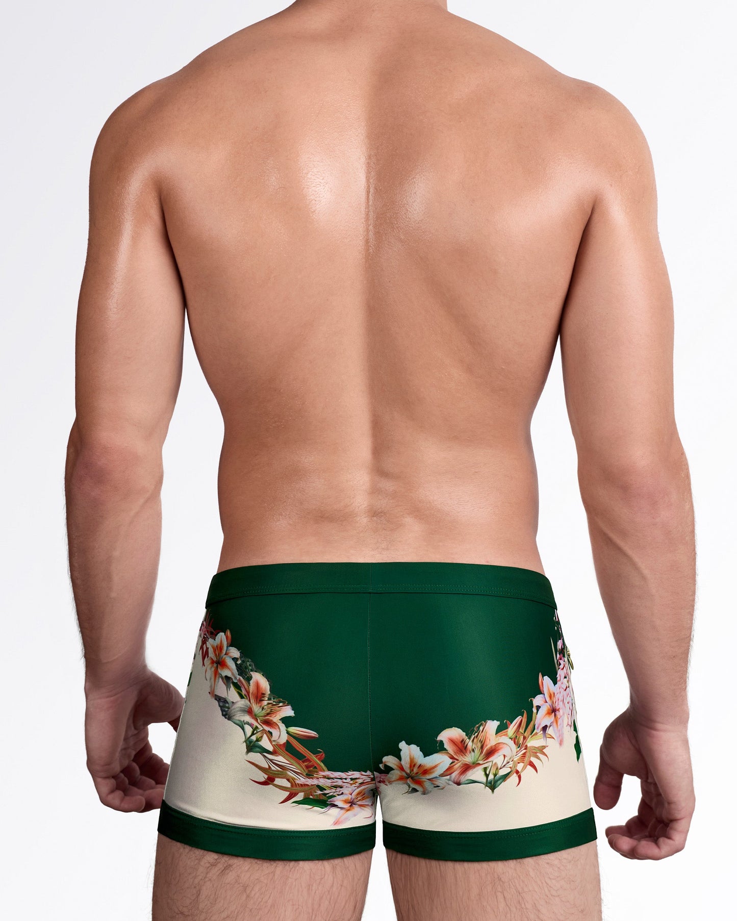 DC2 Bloom Service Swim Trunks — back view showing wraparound floral border design in soft cream and green tones.
