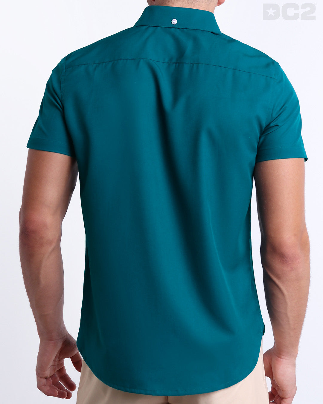 A male model is seen from the back wearing a white CHIC TEAL a Hawaiian shirt from DC2, a Miami-based men’s beachwear brand.