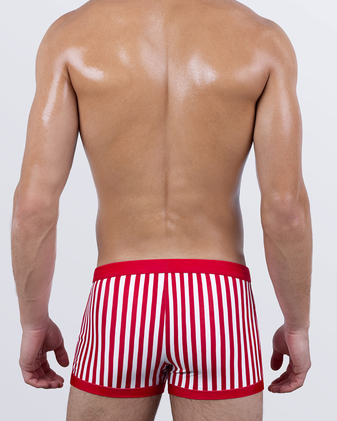 Back view of FAST LINES (RAPID RED) men's swim trunks showing seamless rear coverage and vibrant red striped print. Designed for all-day support and a flattering contour fit.
