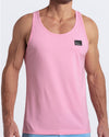 Frontal view of male model wearing the LITERALLY PINK in a solid baby pink color casual gym tank top for men by the DC2 brand of men's beachwear from Miami.