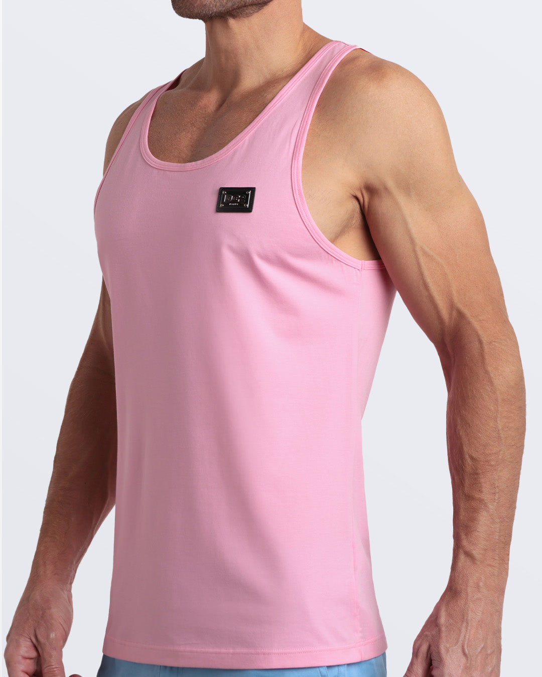 Side view of men’s workout tank top in LITERALLY PINK a light candy pink color with a metallic plaque logo made by DC2 Clothing the new official brand of mens beachwear.
