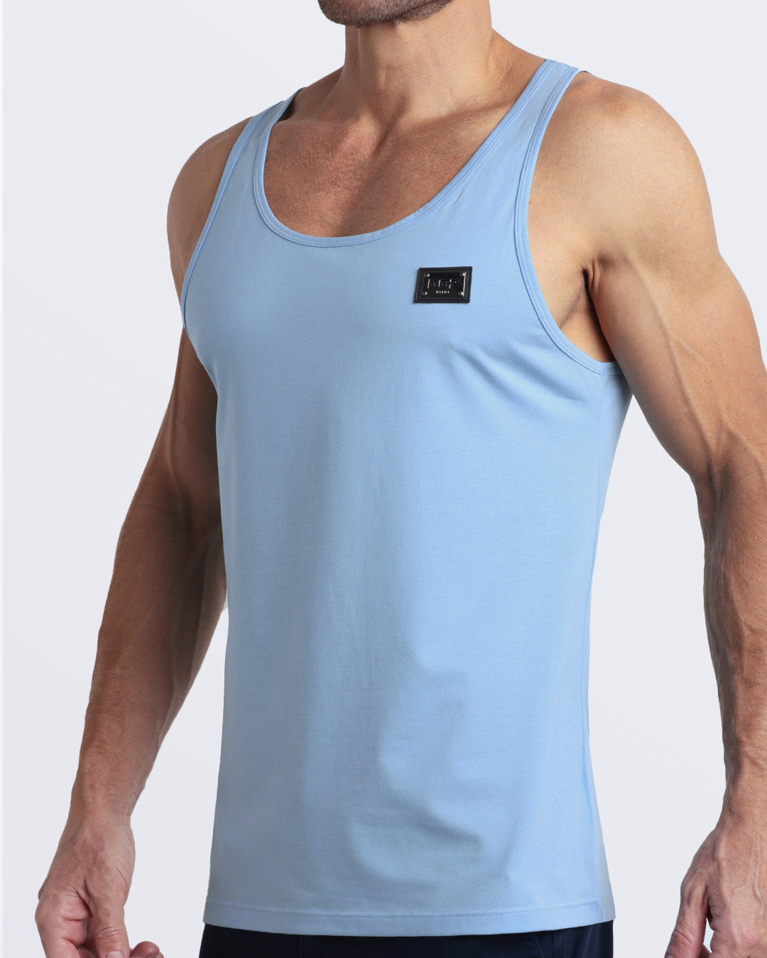 Side view of men’s workout tank top in SKY BLUE a light baby blue color with a metallic plaque logo made by DC2 Clothing the new official brand of mens beachwear.