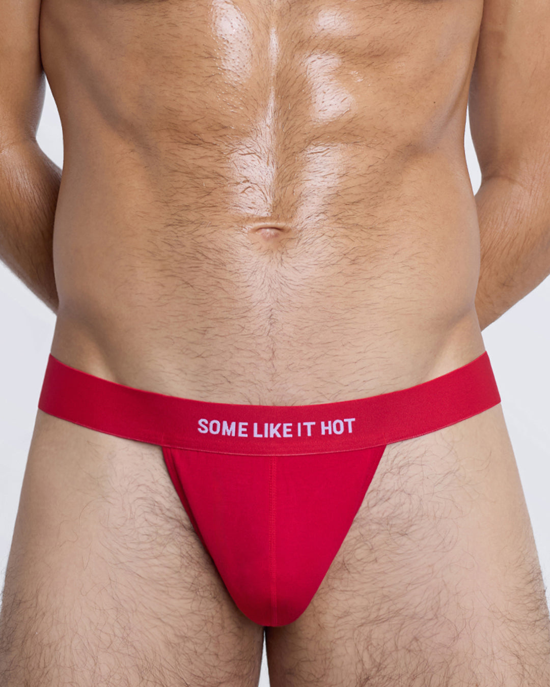 SOME LIKE IT HOT Modal Thong by DC2 — close-up front pouch in red cotton with bold text on elastic waistband.