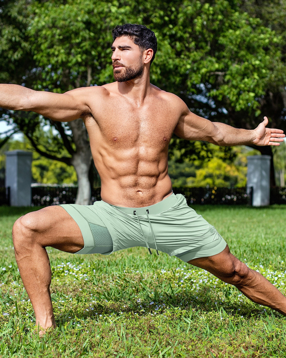 DC2 Track Green Endurance Shorts — lightweight sage green performance shorts with mesh panel detailing, styled during an outdoor workout session.