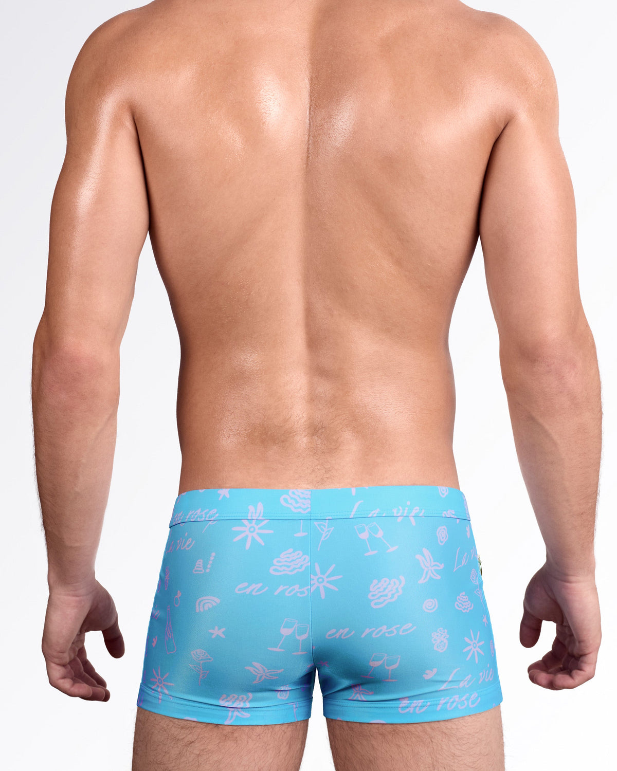 DC2 Viva La Vida (En Rose) Swim Trunk — back view showing full trunk coverage with allover pink graphic motifs including florals, sunbursts, cocktails, and playful line art.