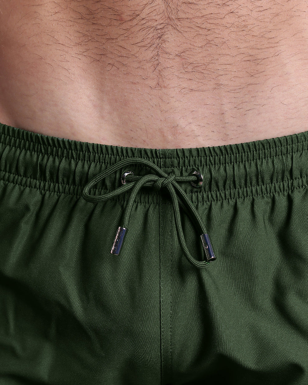 Alpha Green Poolside Shorts infographic highlighting fully closing zip pockets, water-resistant metallic zippers, four-way stretch fabric, and a quad-friendly shorter leg length.