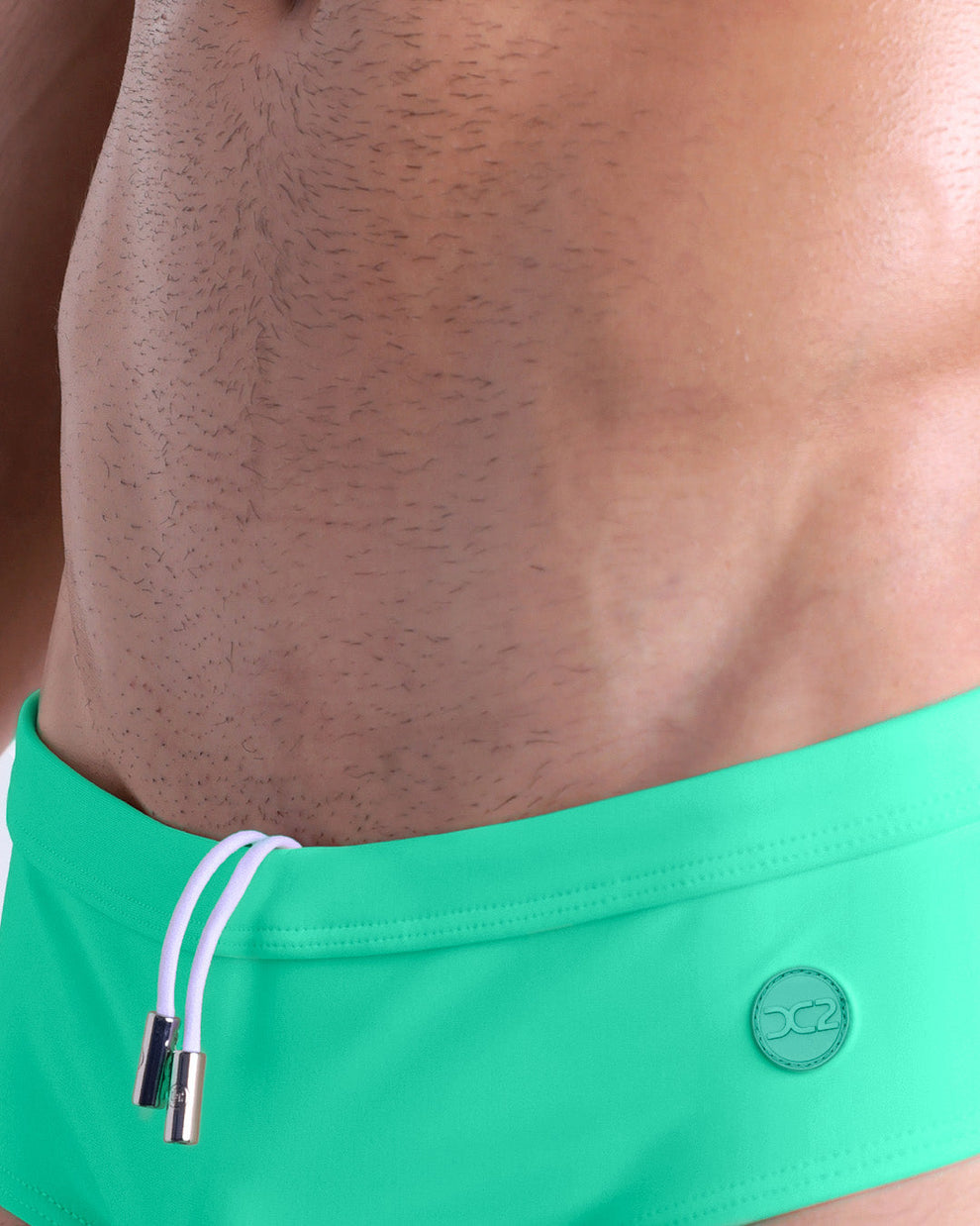 Product detail of Aqua Glow Swim Brief — close-up of waistband with contrast drawstring and DC2 logo.