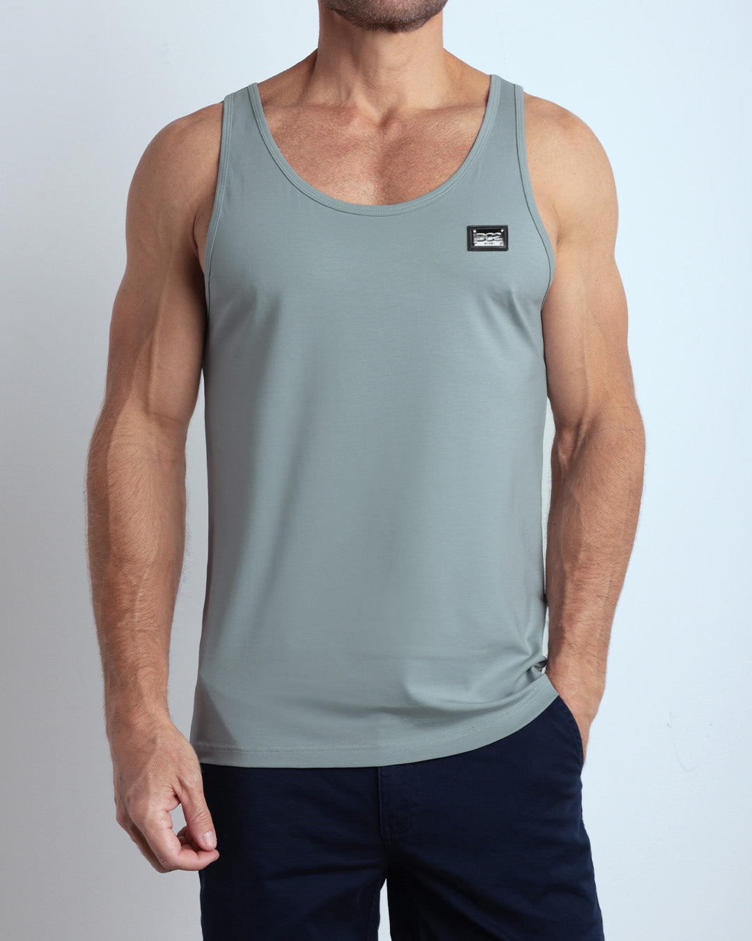 A model wearing the BARELY TEAL men's fitness breathable tank top with the BLOOMING BLUE Street Shorts. The casual beach tank top is made of modal cotton blend in a light teal green color by DC2 Miami menswear.