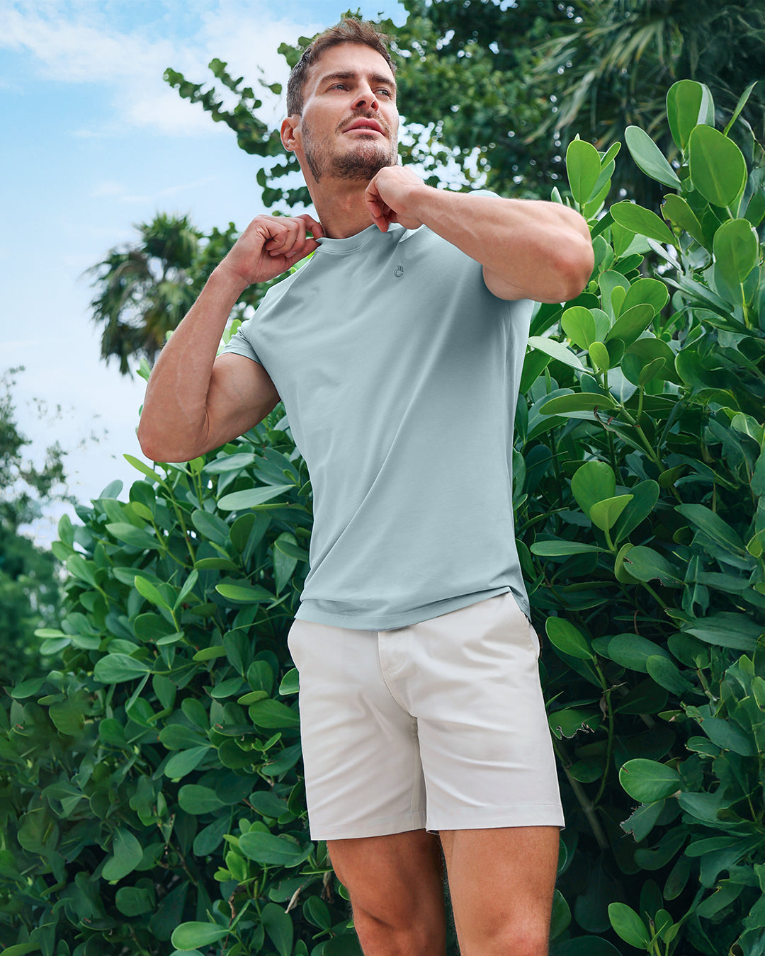 DC2 Barely Teal Modal Cotton T-Shirt paired with The Tile Is High (White) Street Shorts — model standing outdoors surrounded by lush tropical greenery, showcasing the clean, resort-ready look of the outfit.