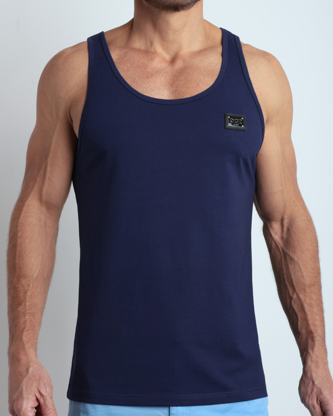 Frontal view of male model wearing the BE MY NAVY in a solid dark royal blue color casual gym tank top for men by the DC2 brand of men's beachwear from Miami.