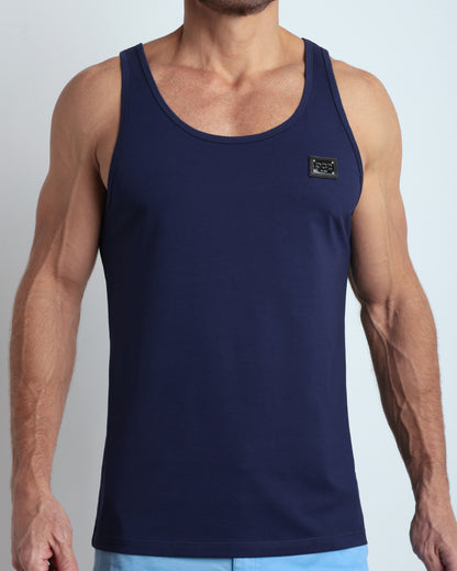 Frontal view of male model wearing the BE MY NAVY in a solid dark royal blue color casual gym tank top for men by the DC2 brand of men's beachwear from Miami.