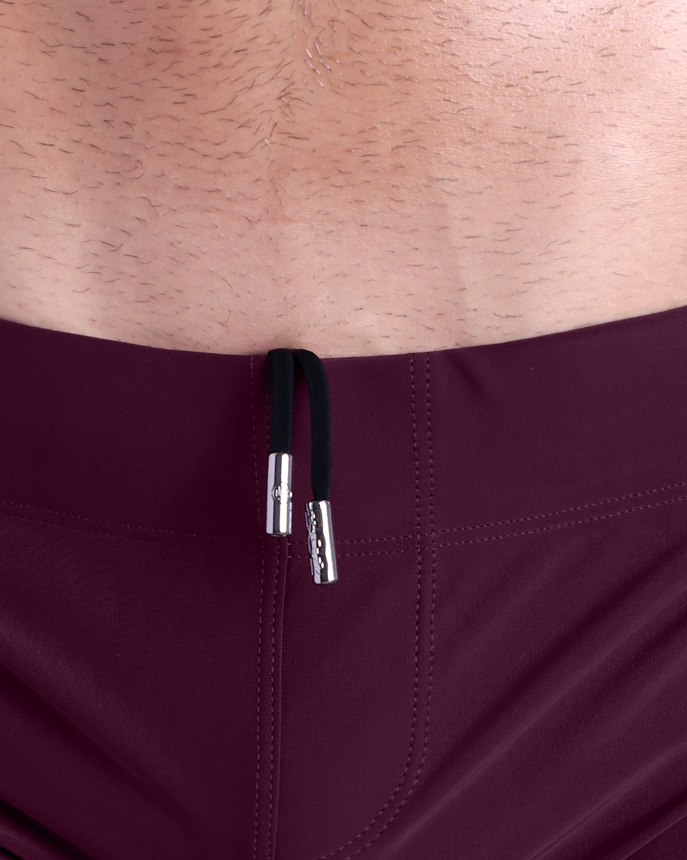 Close-up view of men’s summer beach shorts by DC2 clothing brand, showing black cord with custom branded metallic silver cord ends.