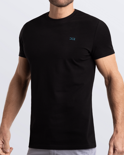 Frontal view of a male model wearing a black Pima cotton t-shirt, crafted for stylish casual wear and beachwear by DC2 Miami. Premium quality men's streetwear t-shirt, perfect fit for summer fashion.