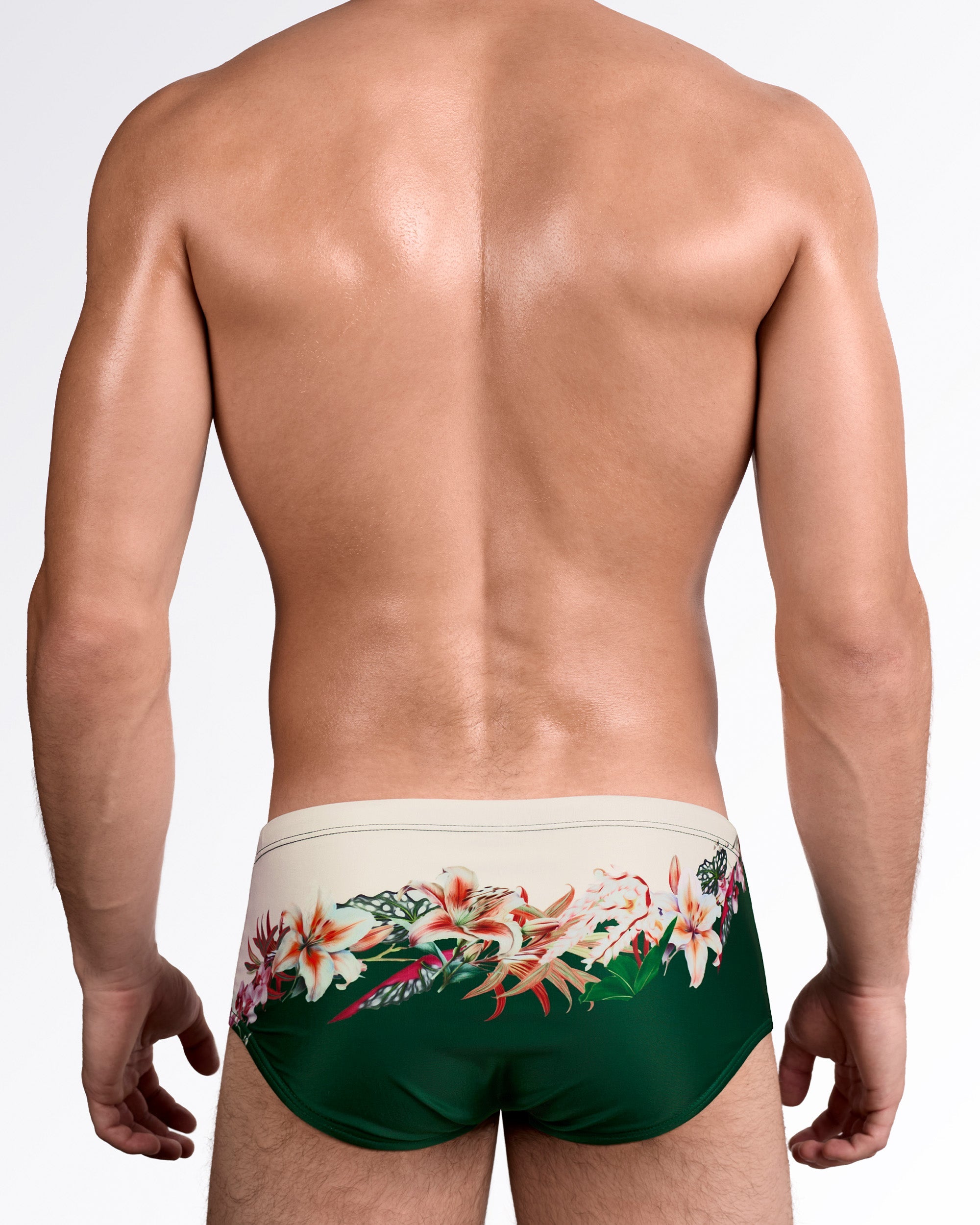 DC2 Bloom Service Swim Sunga — back view showing full coverage rear with floral artwork flowing across the cream and green color-blocked background.