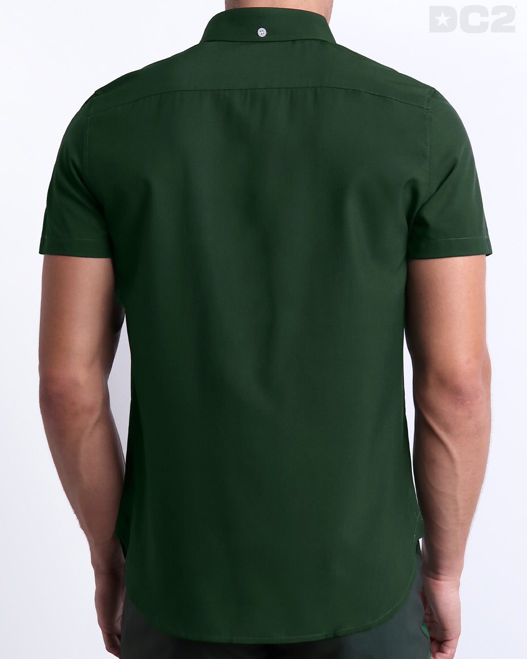 Male model wearing men’s BRAVE GREEN men’s Summer button-down in dark pine green with stylish white and orange colored stripes. This high-quality shirt is by DC2, a men’s beachwear brand from Miami.