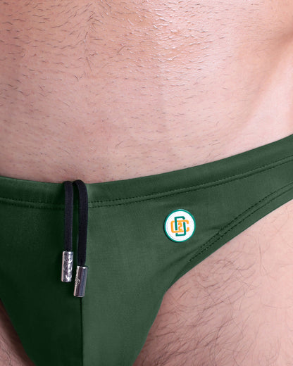 Close-up view of the BRAVE GREEN men’s drawstring briefs showing black cord with custom branded metallic silver cord ends, and custom DC2 logo.