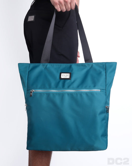 The CHIC TEAL Poolside Tote Bag in a teal blue/green color. This perfect day tripper bag protect your belongings from spills and splashes designed by DC2 in Miami.