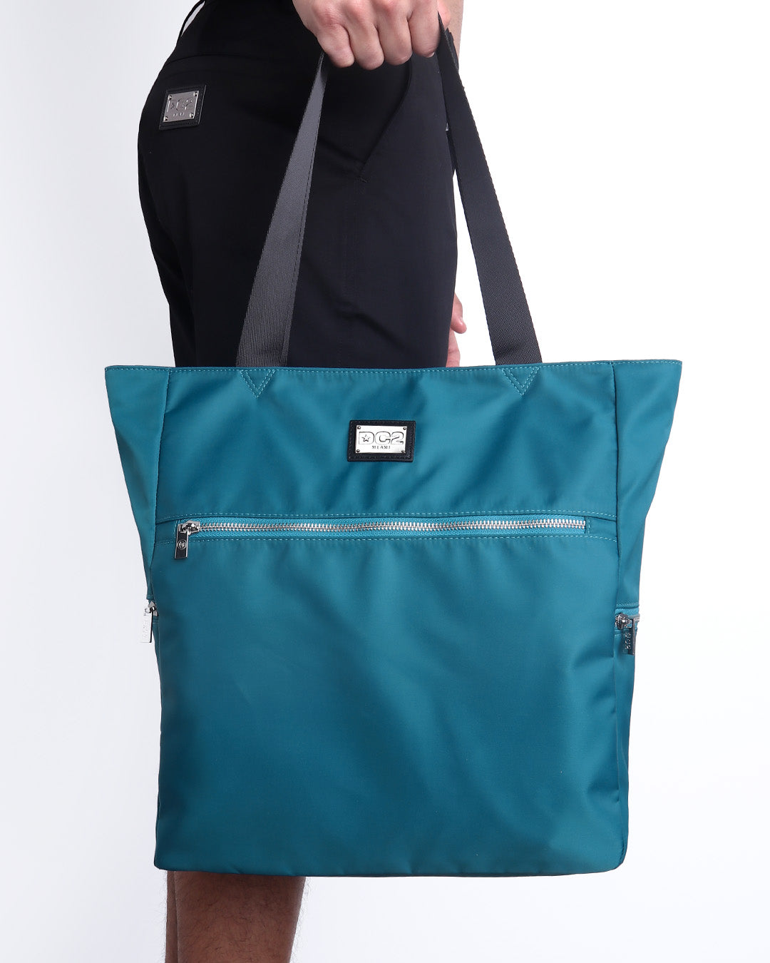 The CHIC TEAL Poolside Tote Bag in a teal blue/green color. This perfect day tripper bag protect your belongings from spills and splashes designed by DC2 in Miami.