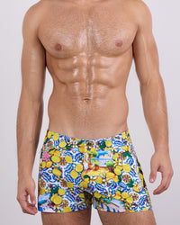 Frontal view of a masculine model wearing the CITRICS CHOICE beach shorts for men by DC2 Miami, a premium swimwear brand. These modern-fit swimming shorts feature a vibrant Mediterranean-inspired print with lemons, floral accents, and intricate blue patterns, offering a bold and stylish look perfect for beach days, poolside lounging, and summer adventures.
