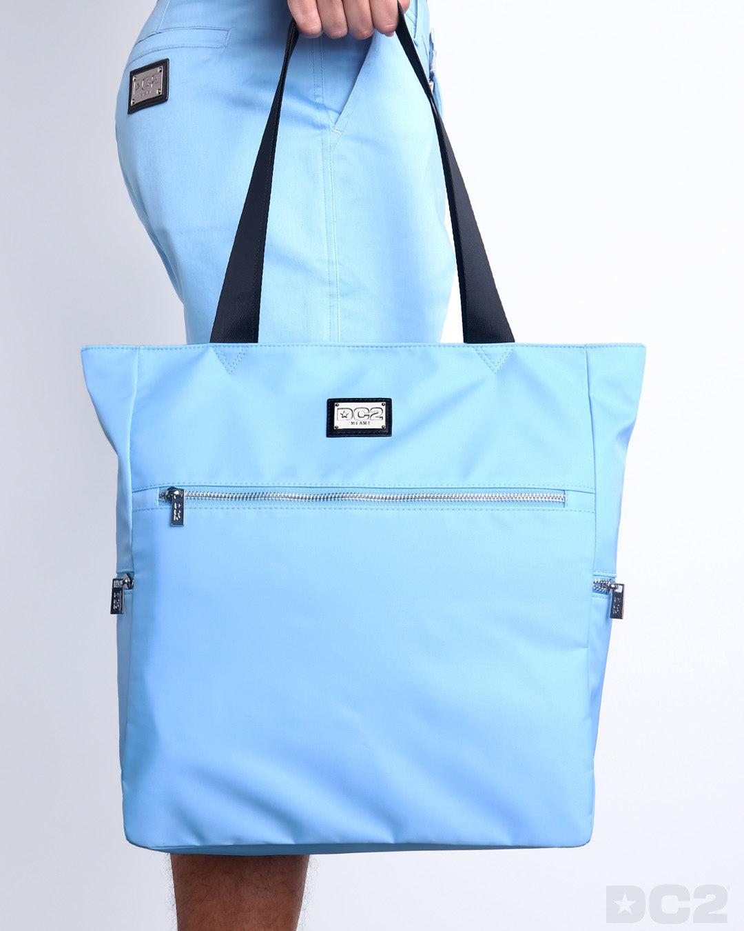 The COASTAL BLUE Poolside Tote Bag in a light blue color. This perfect day tripper bag protect your belongings from spills and splashes designed by DC2 in Miami.