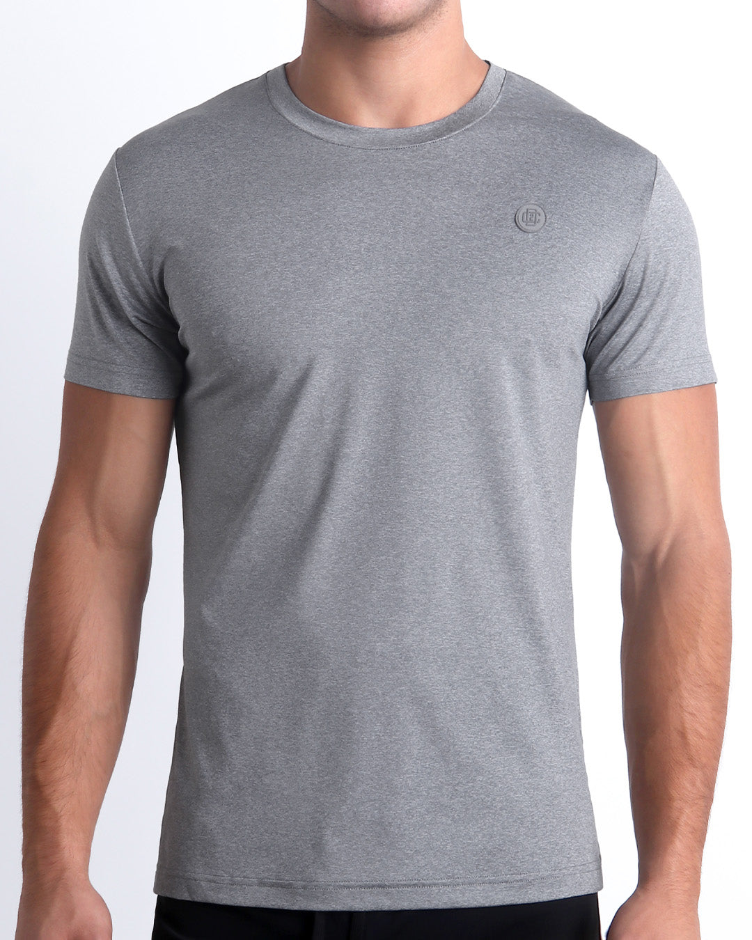 Frontal view of male Model wearing the COMPOUND GREY in a solid heathered grey quick-dry short-sleeve shirt. Designed by DC2 a BANG! Miami Clothes capsule brand.