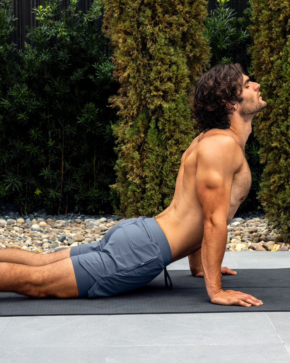 BANG Miami Cross Train Blue Endurance 2-in-1 Gym Shorts — model wearing blue men’s training shorts on a yoga mat outdoors.