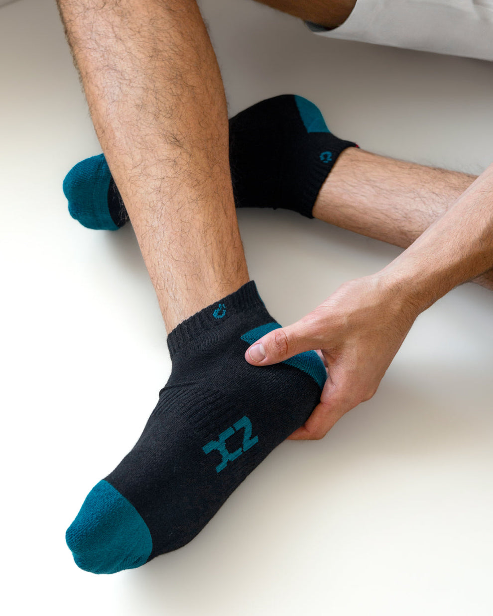 Close-up of DC2 Daily Ankle Socks in black and teal cotton, featuring contrast toe and heel accents with signature logo detailing.