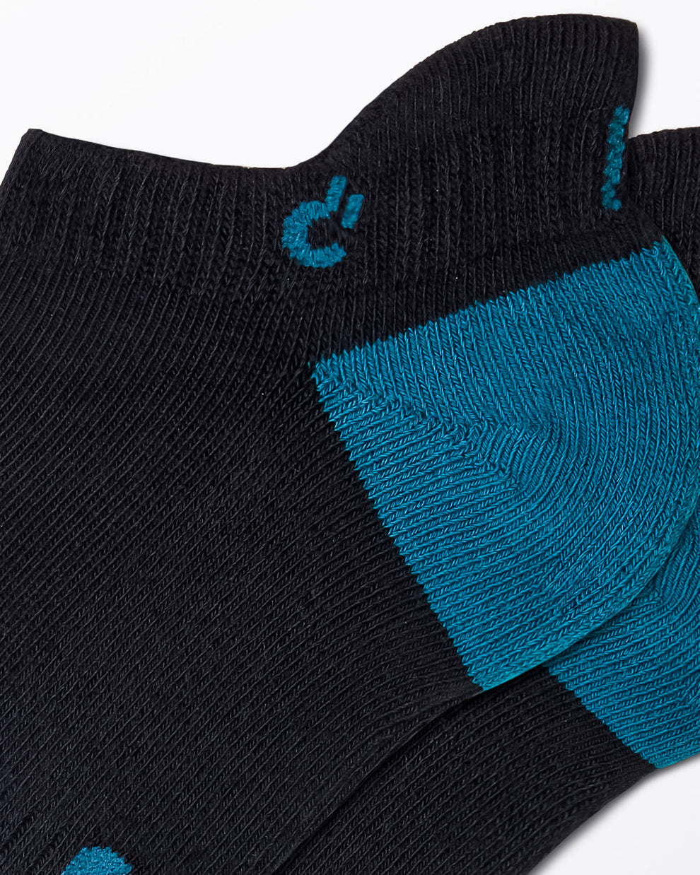 DC2 Daily Ribbed Ankle Socks (Black + Teal) — close-up of teal heel, ribbed knit texture, and small DC2 logo on cuff.
