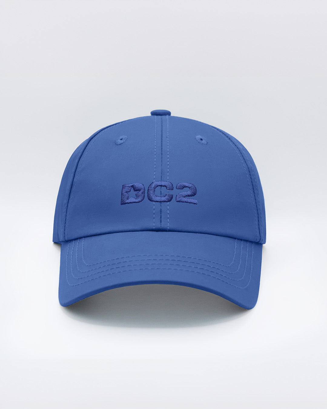 Front view of the DENIM BLUE Chillax Cap, showcasing the bold DC2 logo embroidered in blue on the front panel. The cap features a sleek design with a curved brim and clean lines, made from premium denim blue fabric.