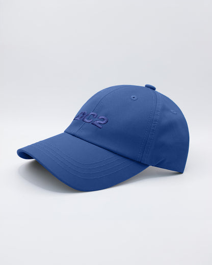 Angled view of the DENIM BLUE Chillax Cap, featuring a sleek and minimalist design in solid blue. The cap is made from high-quality fabric, with a curved brim and subtle stitched logo from DC2 Miami on the front panel.