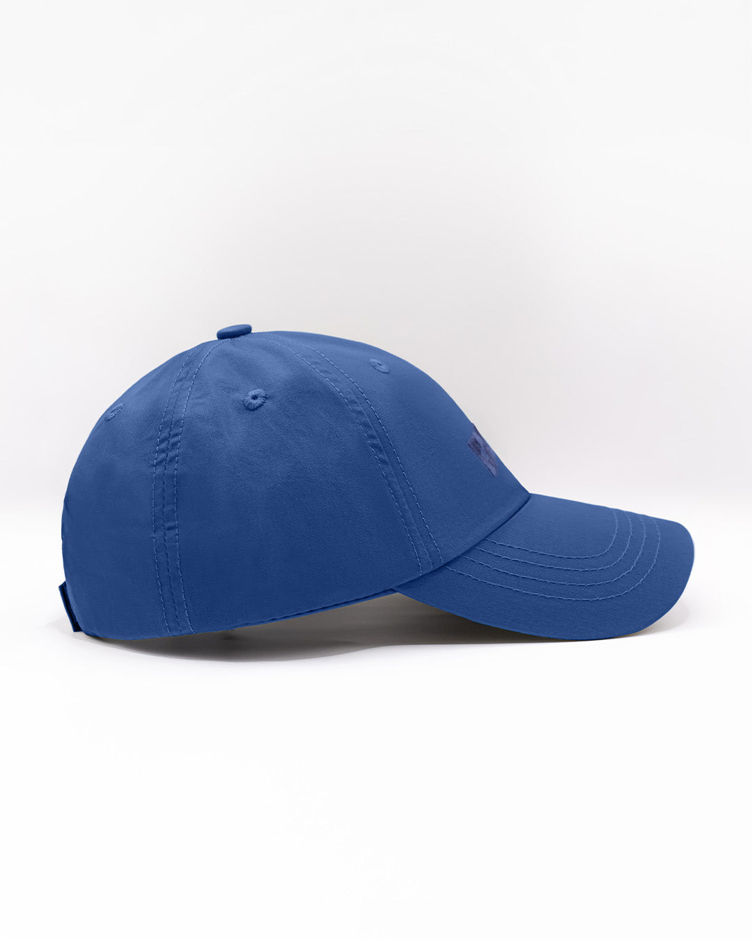 Angled view of the DENIM BLUE Chillax Cap, featuring a sleek and minimalist design in solid blue. The cap is made from high-quality fabric, with a curved brim and subtle stitched logo from DC2 Miami on the front panel.