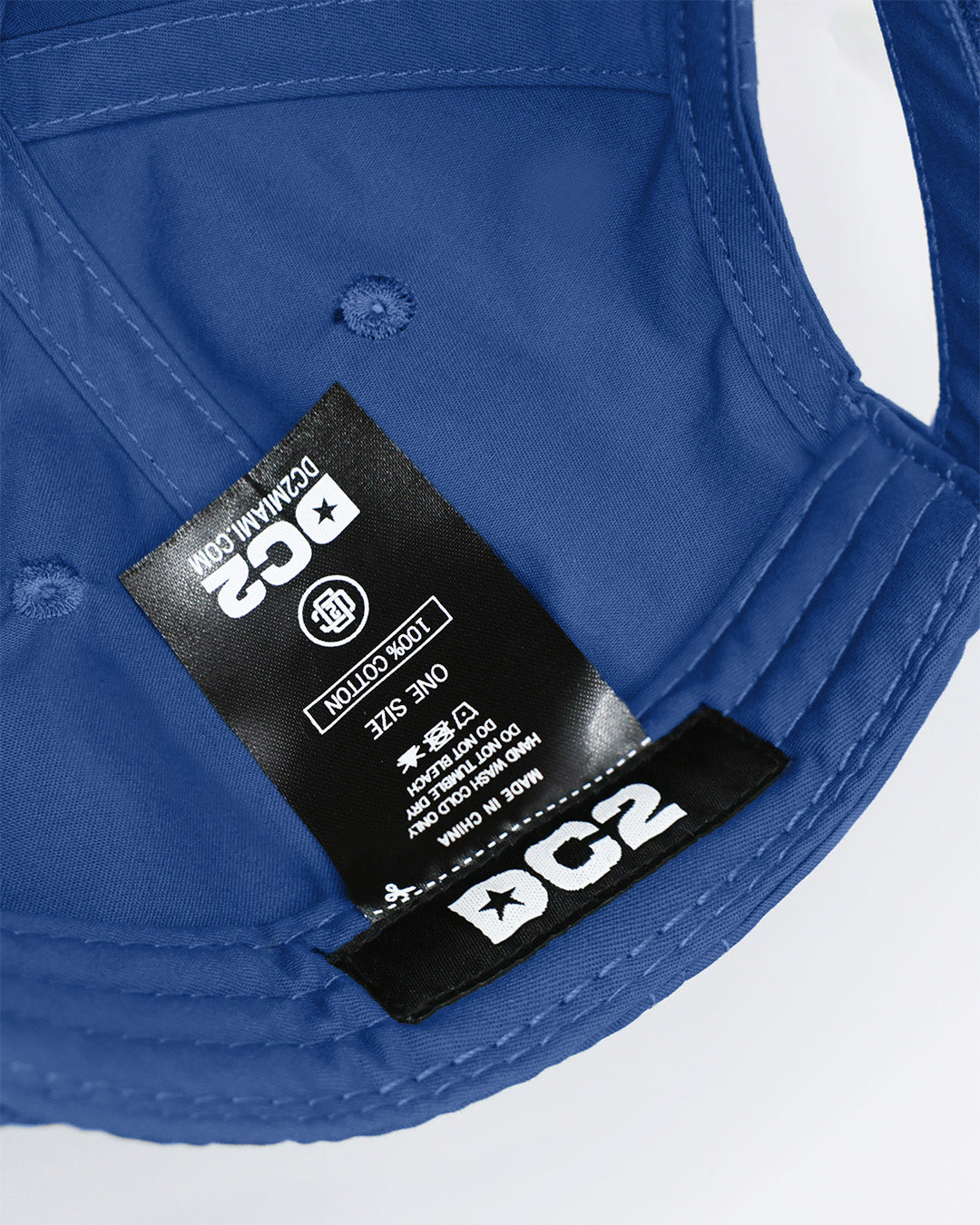 Close-up of a DENIM BLUE Baseball Cap care tag from DC2 Clothing from Miami.