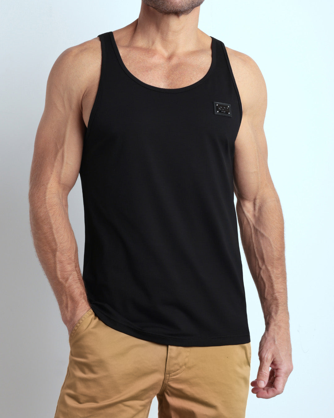 A model wearing the EXACT BLACK men's fitness breathable tank top with the SAFARI BROWN Street Shorts. The casual beach tank top is made of modal cotton blend in a solid dark black color by DC2 Miami menswear.