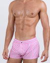 Frontal view of a masculine model wearing the FAST LINES (CHILL PINK) Mini Shorts for men by DC2 Miami, a premium swimwear brand. These ultra-short beach shorts feature a playful pink-and-white striped pattern, an elastic waistband with an adjustable internal drawstring, and a sleek fitted cut, making them perfect for vibrant summer looks, beach days, and poolside lounging.
