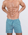 FAST LINES (PACIFIC GREEN) Resort Shorts by DC2 Miami, featuring a relaxed fit, four-way stretch fabric, and an above-knee length for extra comfort. The shorts come in a bold green and white striped pattern with an elastic waistband and an adjustable drawstring.