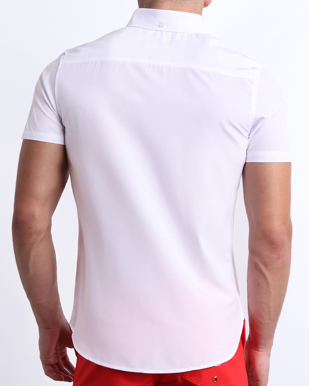 Back view of a male model wearing a FORZA WHITE men’s Hawaiian shirt featuring a white color. This high-quality shirt is by DC2, a men’s beachwear brand from Miami.