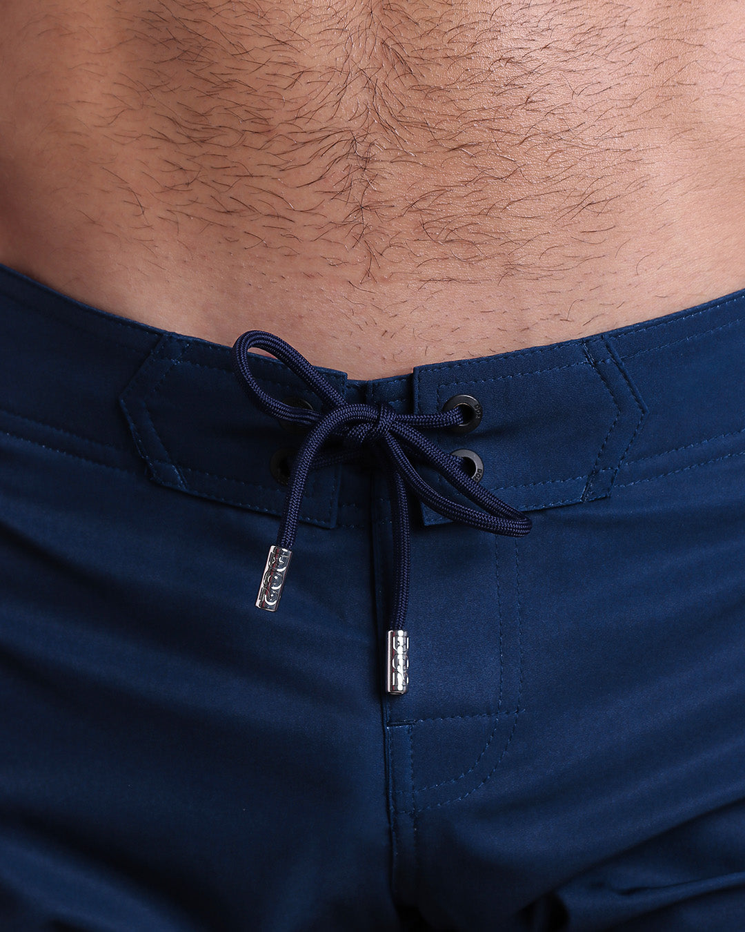 Close-up view of men’s summer Flex shorts by DC2 clothing brand, showing blue color cord with custom-branded golden cord ends, and matching custom eyelet trims in gold.