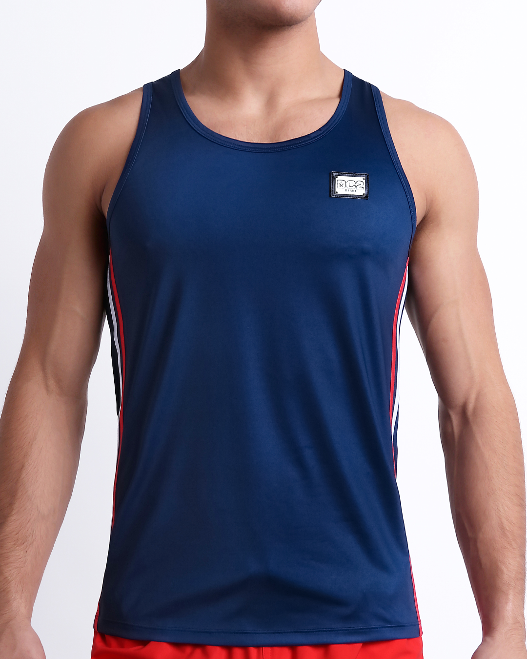 Male model wearing IMPERIAL BLUE men’s casual Tank Top. A premium quality top in a solid navy color with red and white stripes on the sides, a men’s beachwear brand from Miami.