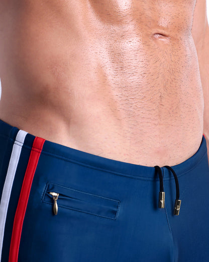 Close-up view of the IMPERIAL BLUE men’s drawstring briefs showing black cord with custom branded metallic gold cord ends, and matching custom eyelet trims in gold.