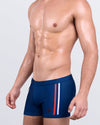 DC2 IMPERIAL BLUE Swim Trunks — model wearing square-cut Swim Trunks featuring side racing stripes and zippered mini pocket.