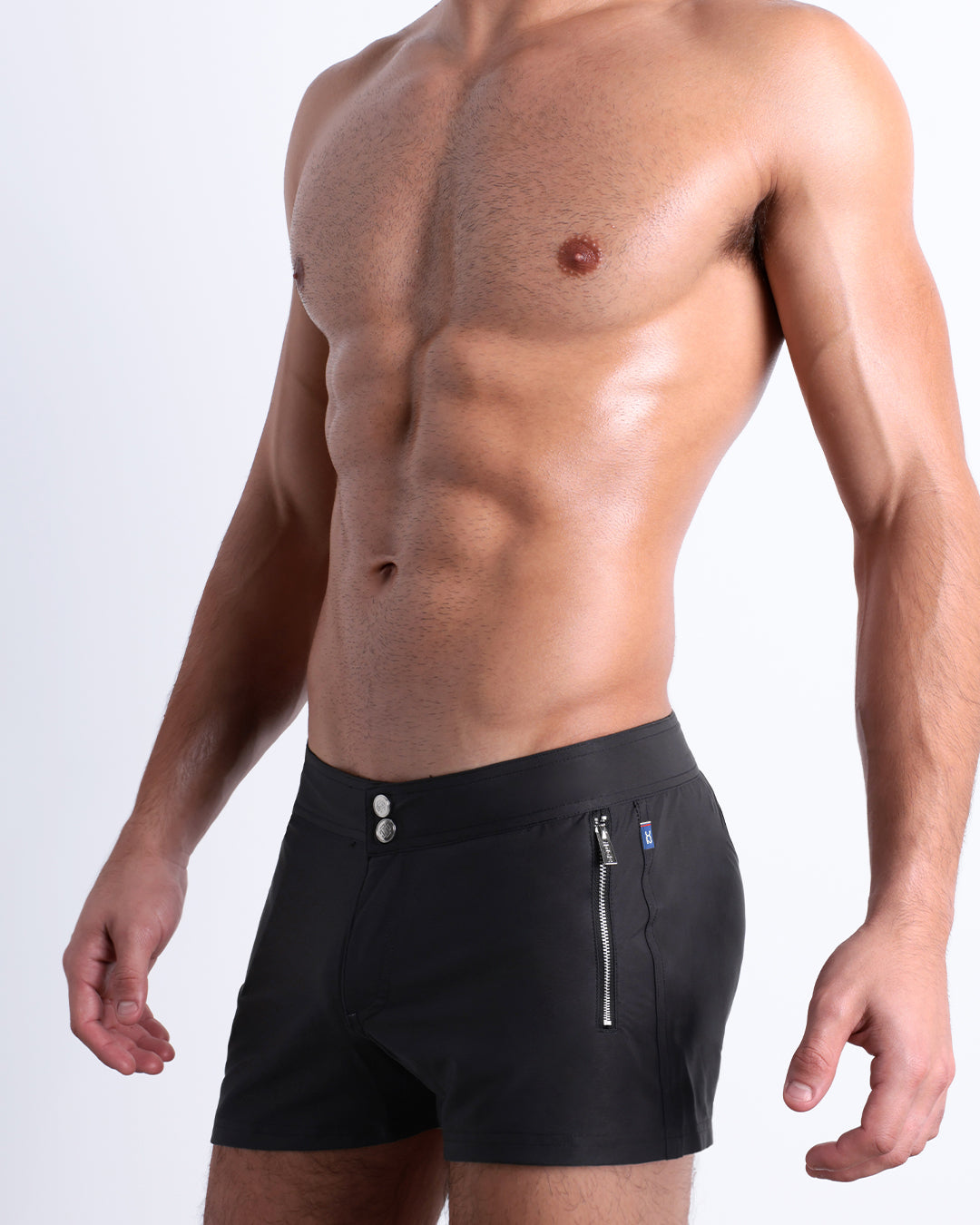Jet Black Beach Shorts featuring a modern fit, flat waistband, metallic zip pockets, and a sleek tailored silhouette with a built-in brief liner.