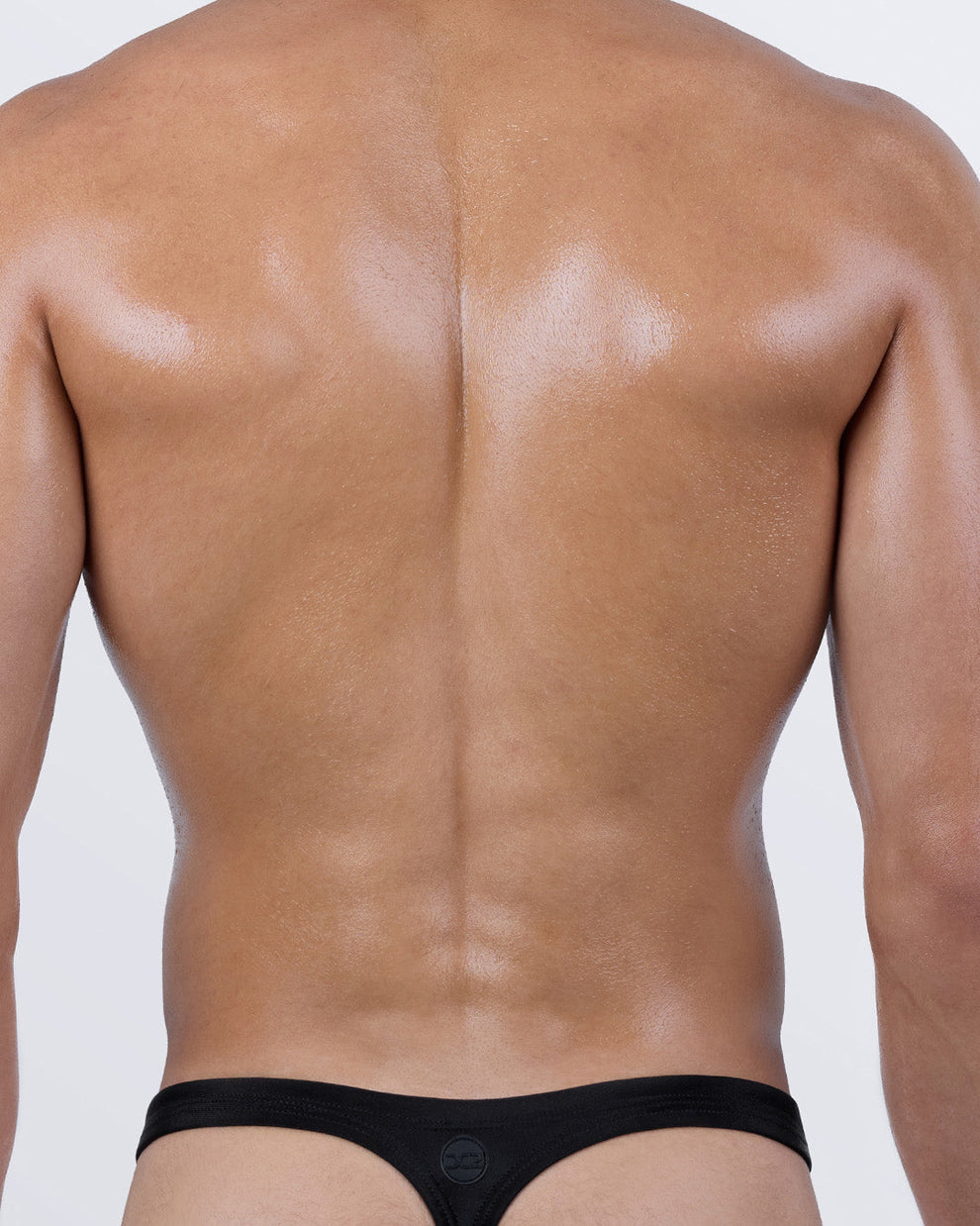 Back view of DC2 JET BLACK men's thong swimwear – classic T-back design ideal for tanning with sculpted fit and sleek micro coverage.