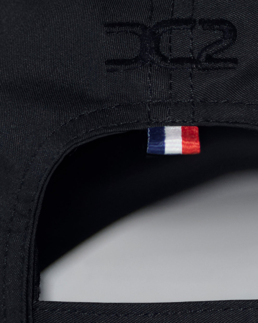Interior detail of DC2 White Resort Cap — soft cotton lining, adjustable strap, and branded care label.
