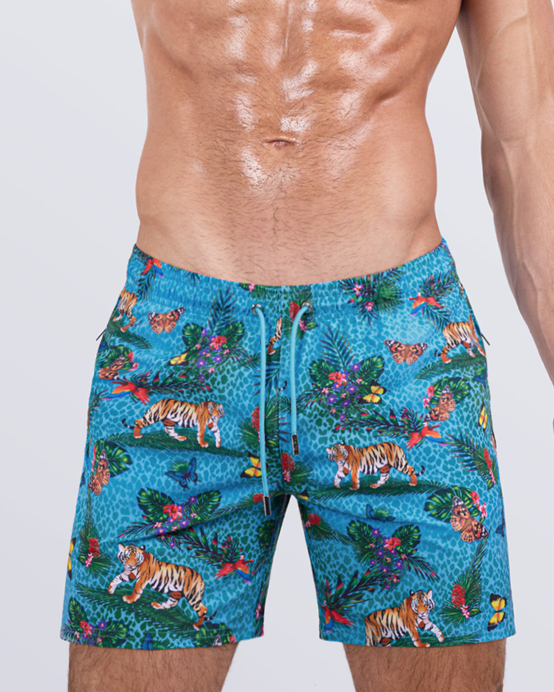 Close-up side view of a male model in the JUNGLE BOOGIE Resort Shorts for men by DC2 Miami. These striking swim shorts feature premium four-way stretch fabric, metallic zip pockets for secure storage, and water-resistant properties, making them perfect for both active beach days and casual summer outings.