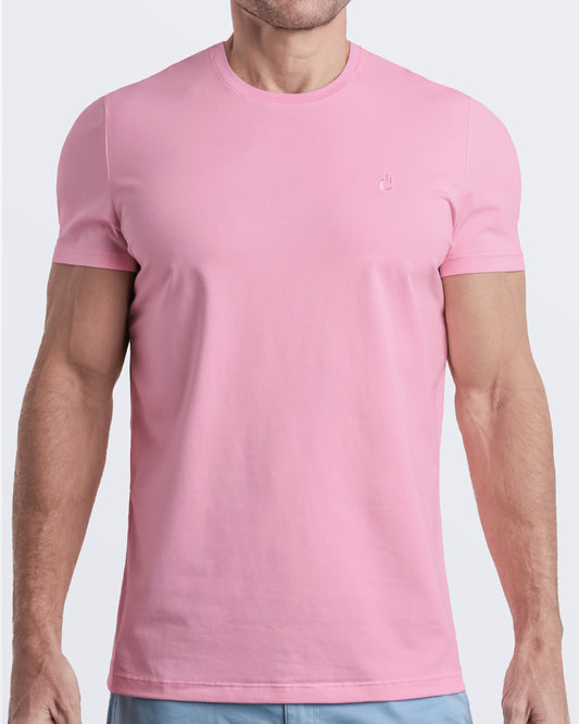 Frontal view of a male model wearing a light pink color modal cotton t-shirt, crafted for stylish casual wear and beachwear by DC2 Miami. Premium quality men's streetwear t-shirt, perfect fit for summer fashion.