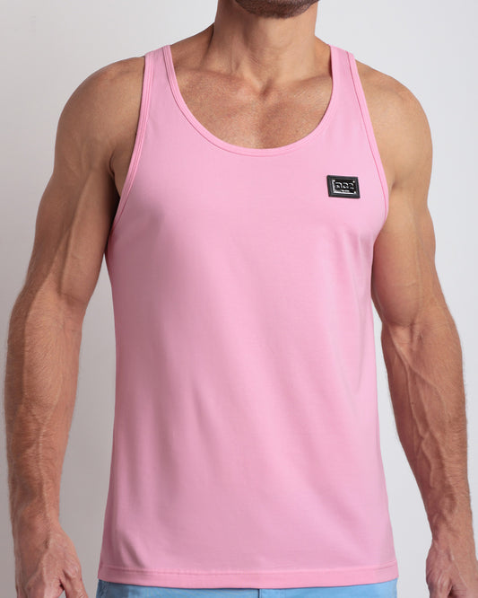 Frontal view of male model wearing the LITERALLY PINK in a solid baby pink color casual gym tank top for men by the DC2 brand of men's beachwear from Miami.