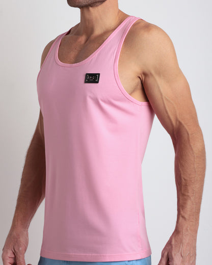 Side view of men’s workout tank top in LITERALLY PINK a light candy pink color with a metallic plaque logo made by DC2 Clothing the new official brand of mens beachwear. 