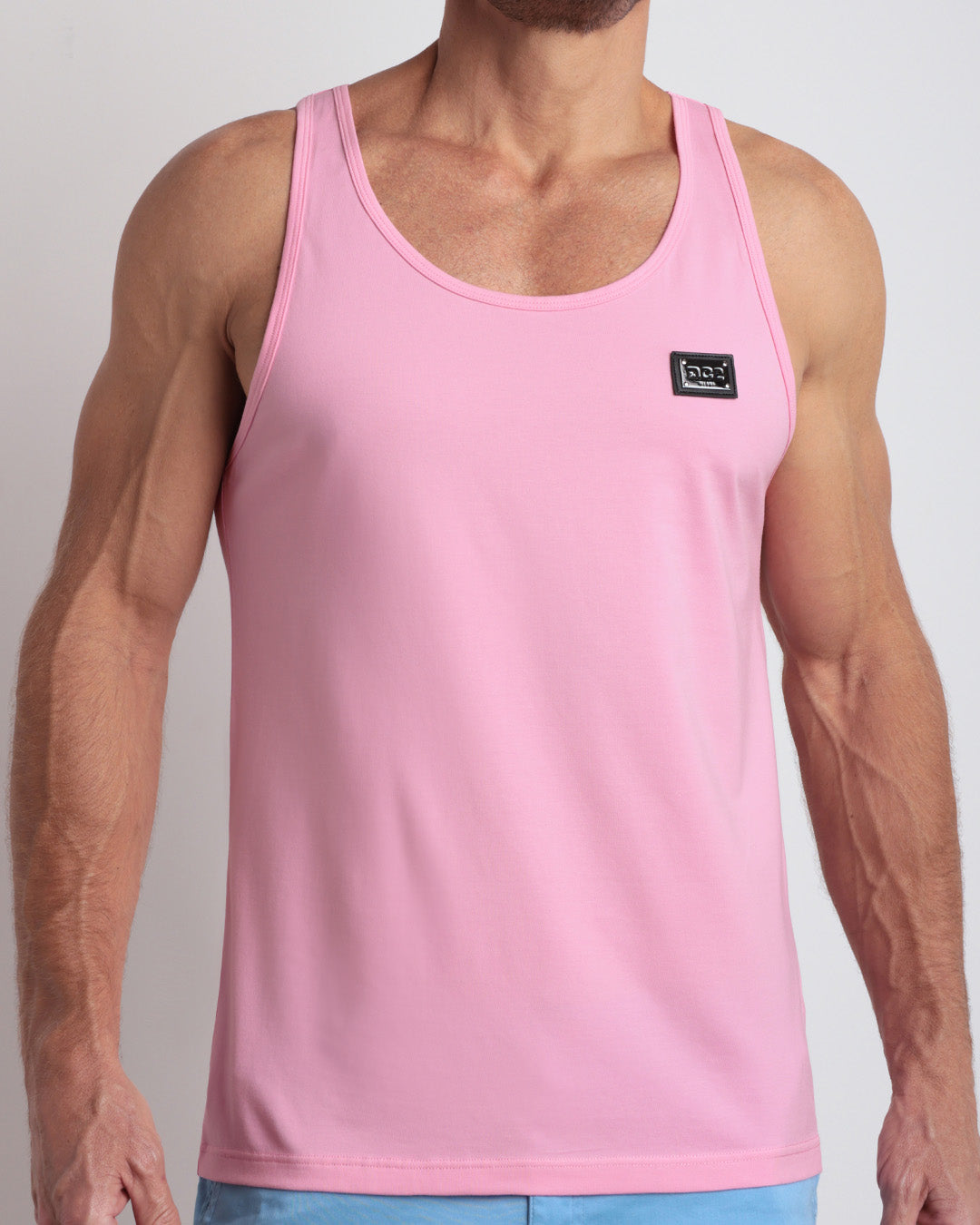 A model wearing the LITERALLY PINK men's fitness breathable tank top with the BREEZY BLUE Street Shorts. The casual beach tank top is made of modal cotton blend in a solid light pastel pink color by DC2 Miami menswear.