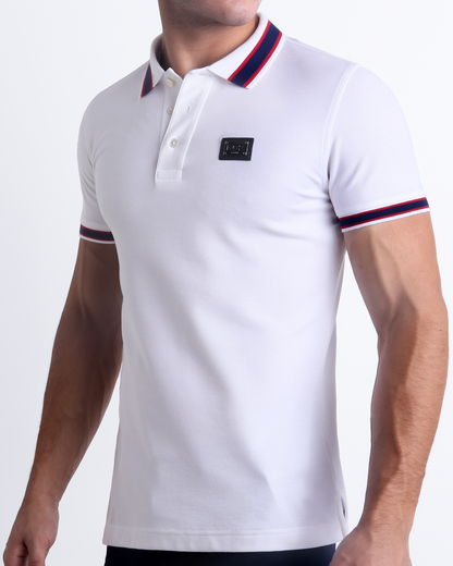 Male model wearing a slim-fitting, LOTUS WHITE Pima Cotton Polo Shirt by Miami-based DC2. Solid white with red and navy blue stripes on ribbed-knit collar and cuffs.